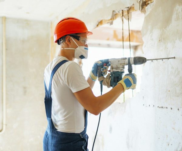 Repairer in boilersuit holding tools. Apartment repair and renovation concept. Building.